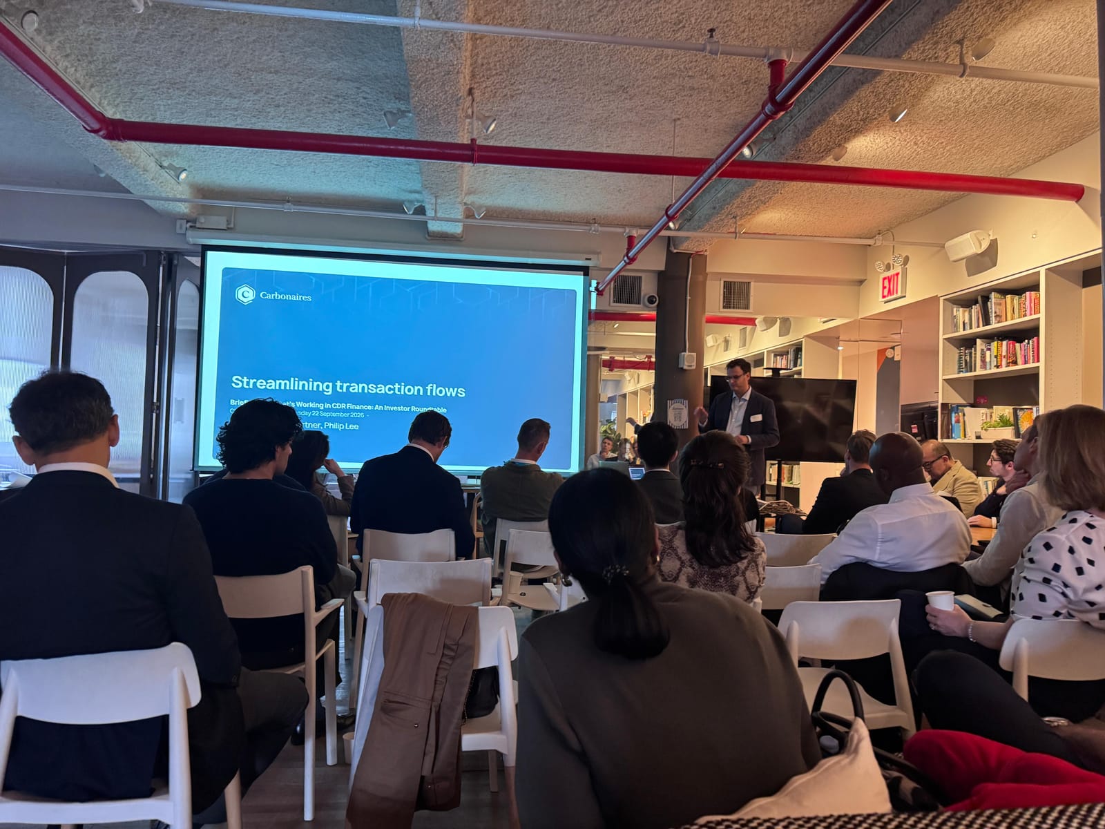 Ryan Covington of Philip Lee presenting a Carbonaires slide titled “Streamlining transaction flows” to roundtable participants seated in rows
